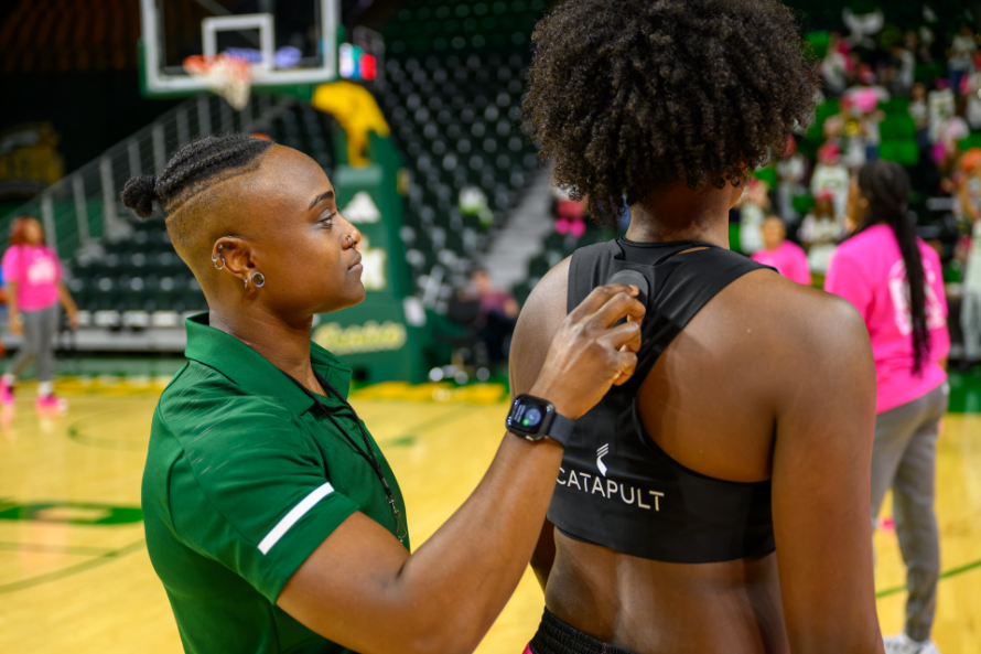 Faith Brown using Catapult technology on women's basketball player for load monitoring.