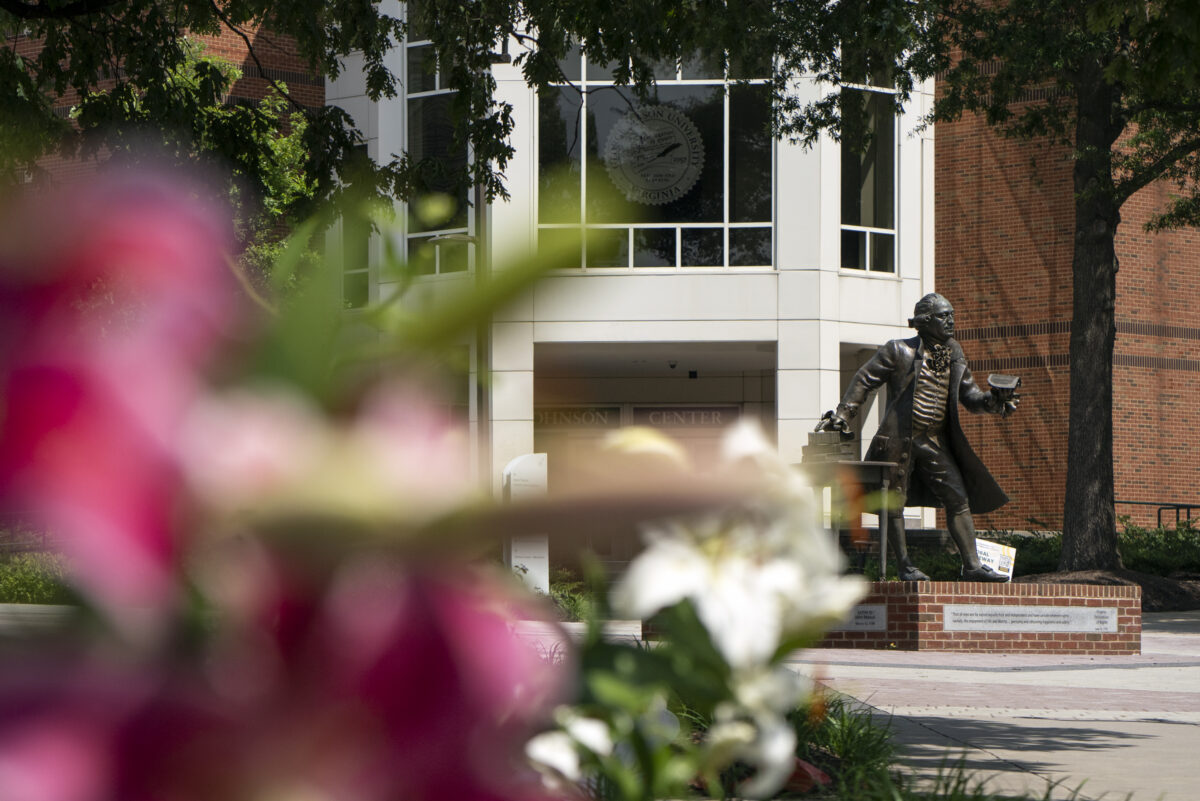 Flowers framing the George Mason statue on the Fairfax campus